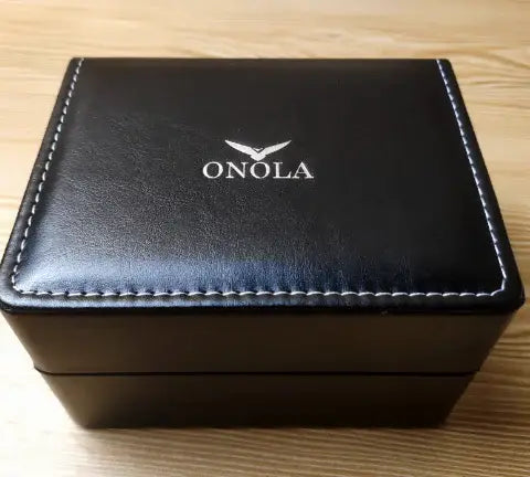 ONOLA men's watch by Wristly featuring a sleek design with a round face and leather strap in a stylish setting.