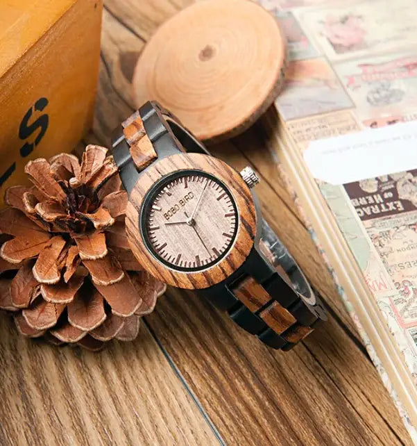 Wooden couple watches set with striped wood and black band placed on wooden surface with pinecones