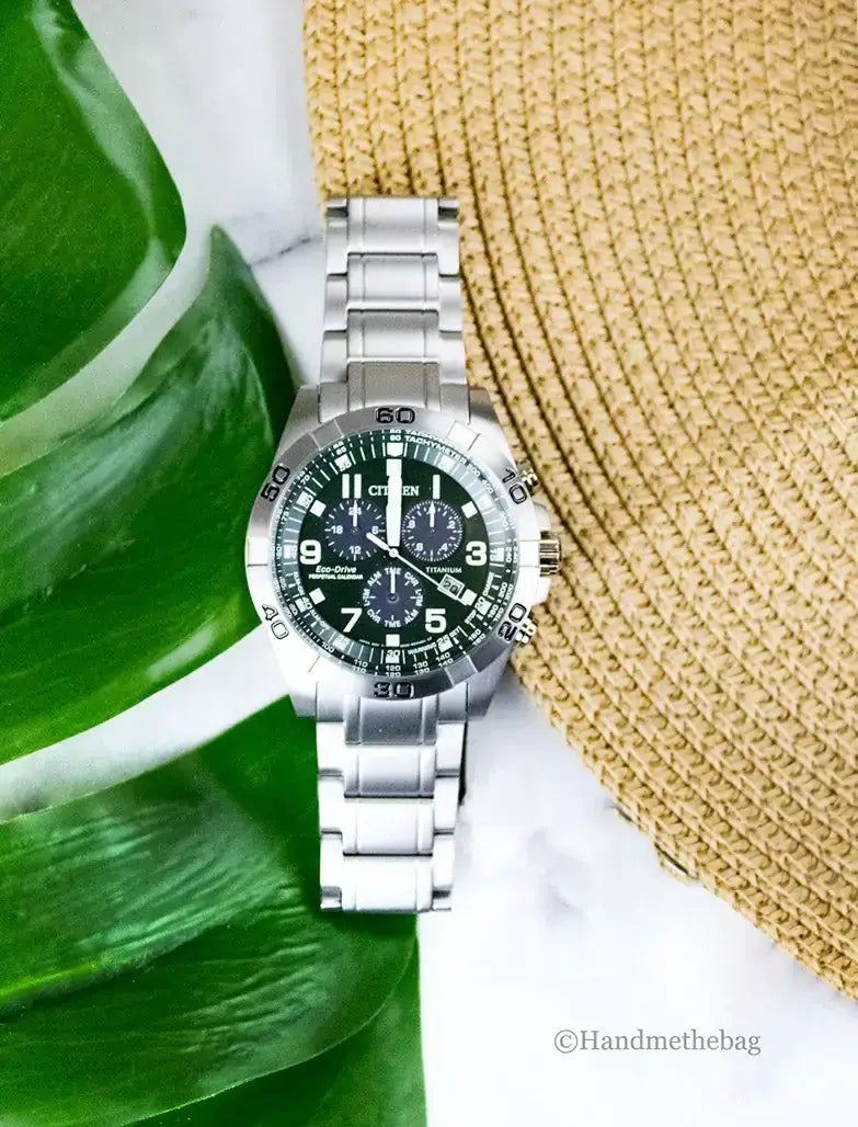 Citizen Weekender Sport Eco-Drive watch with green dial and stainless steel band on a neutral background.